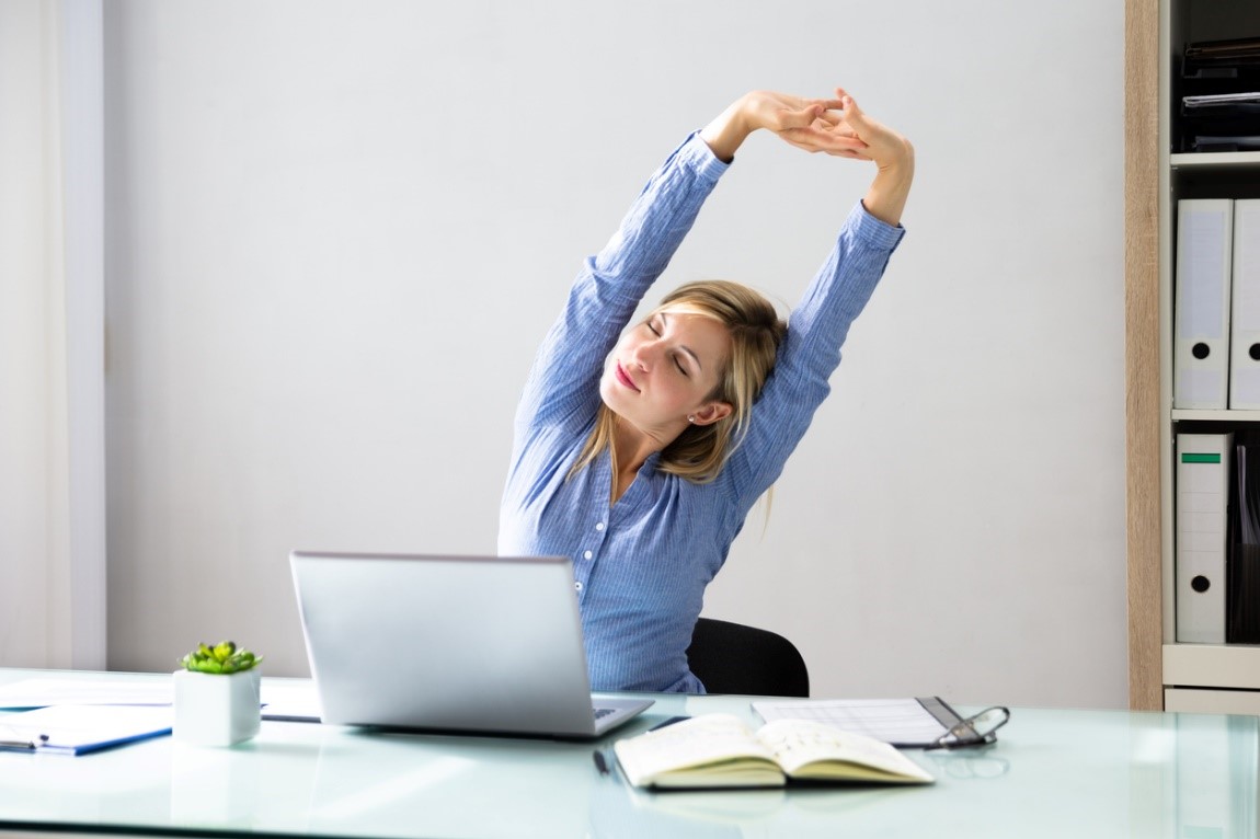 Office worker seated at a well-arranged desk with upright posture and relaxed shoulders